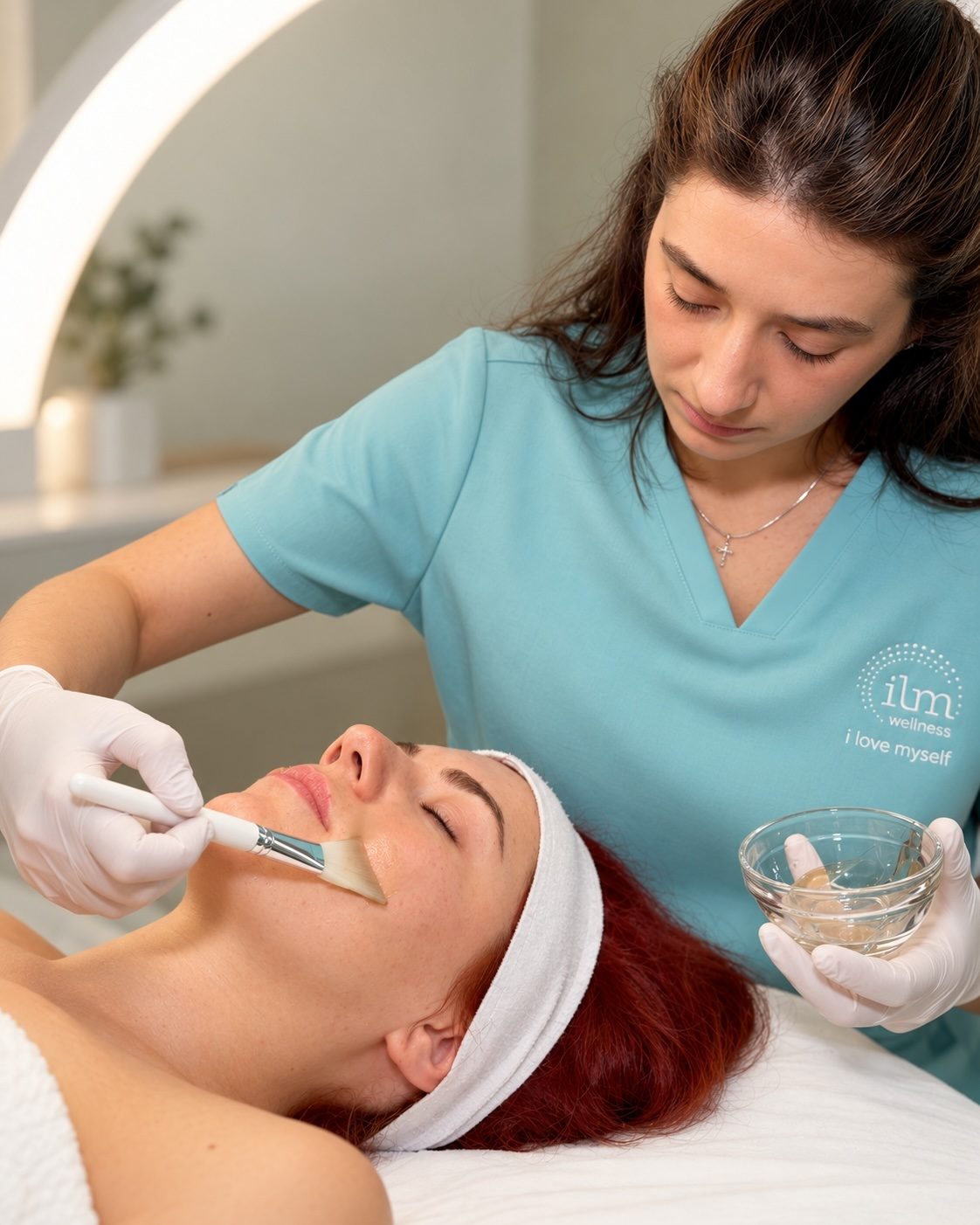 Esthetician applying a treatment mask at ILM Wellness